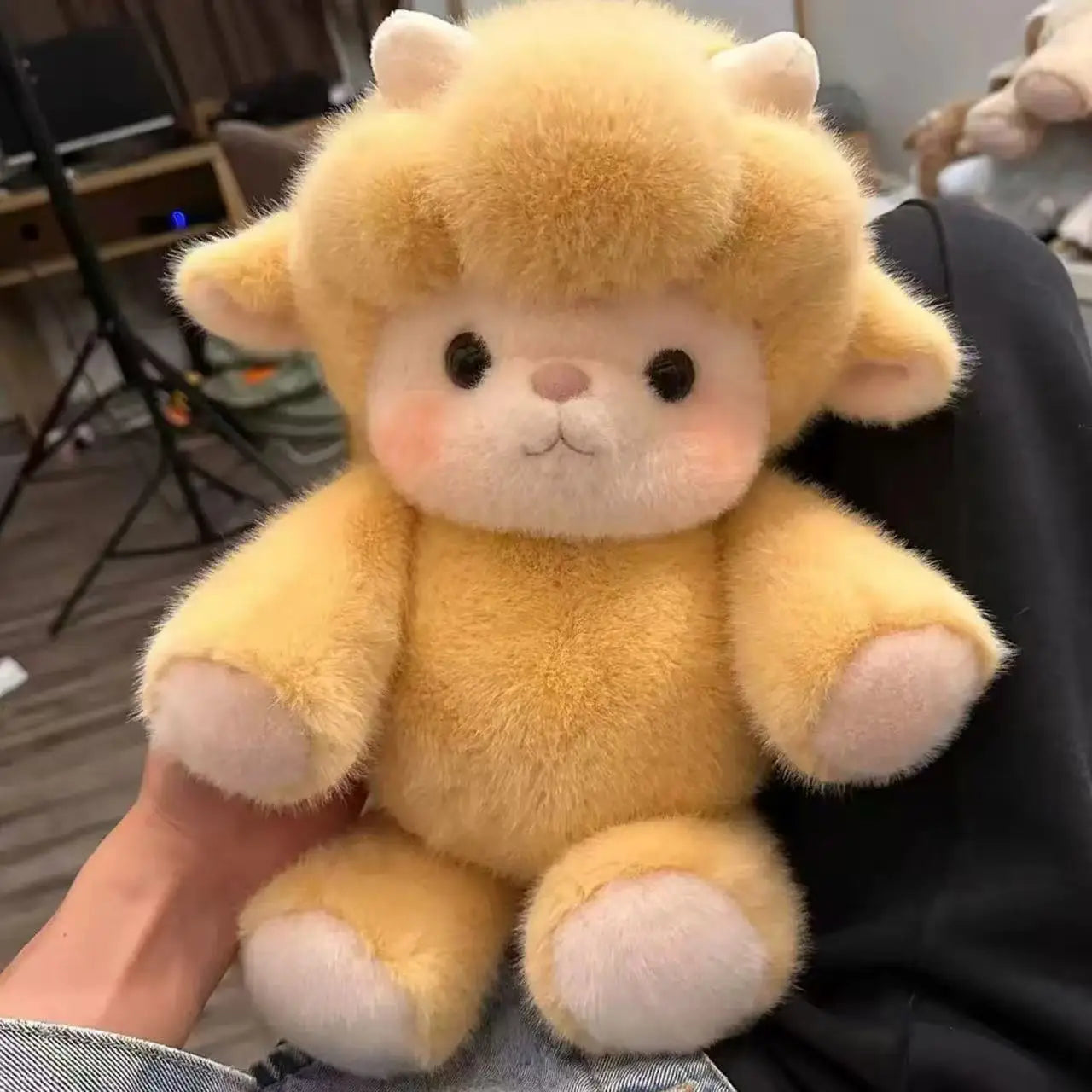 Plush toy monkey held by a person in an indoor setting