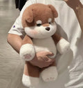 Person holding a brown and white plush dog toy