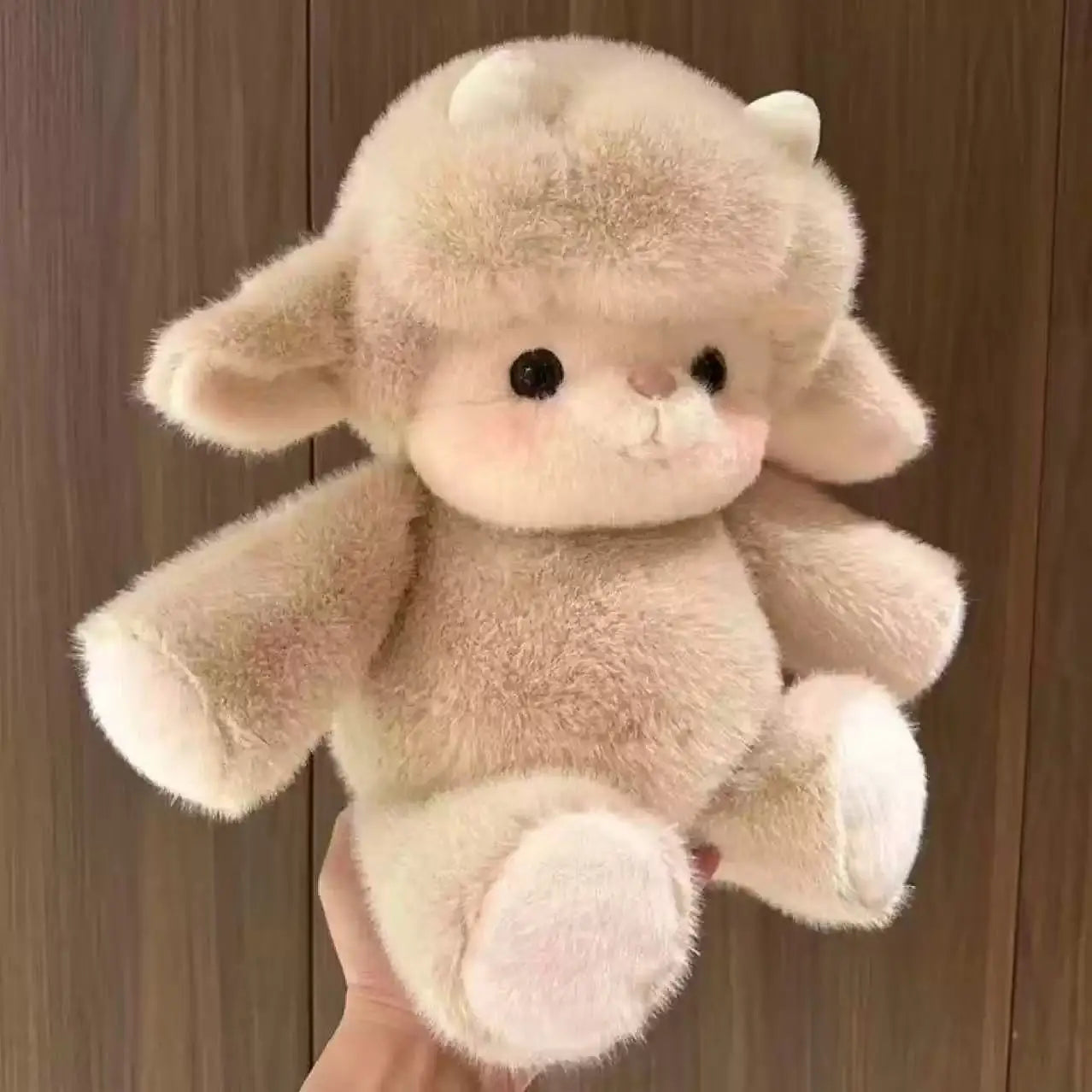 Plush toy with large ears held against a wooden background